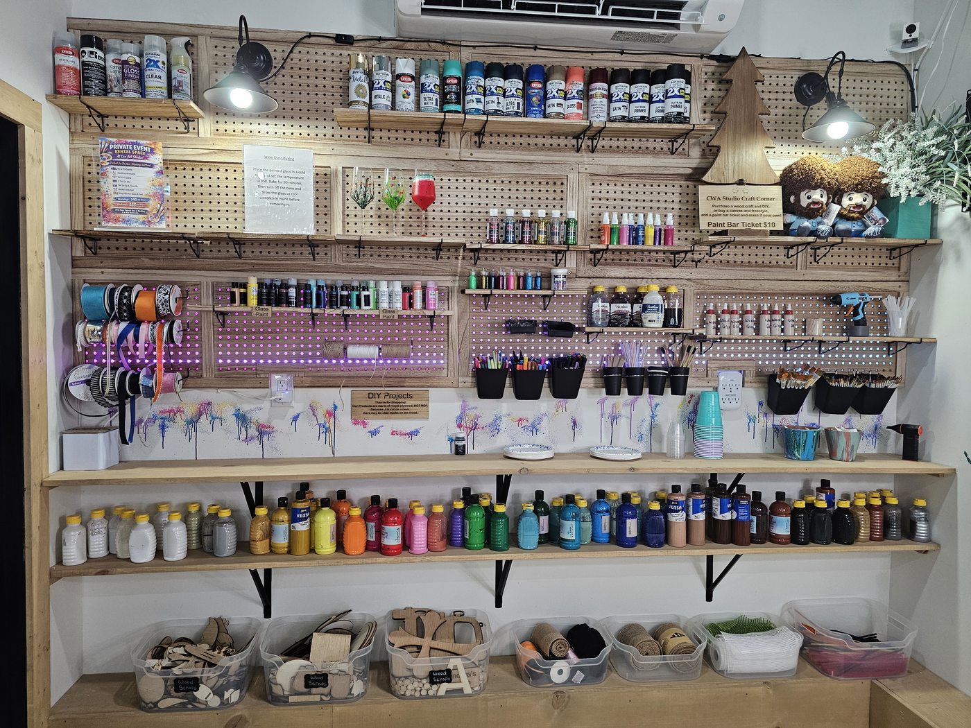 Fully stocked acrylic paint bar with colorful paints, brushes, and DIY supplies